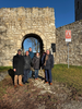Vertreter der Kulturstiftung Sachsen-Anhalt, des Burgenlandkreises und der Stadt Eckartsberga stehen gemeinsam vor dem Burgtor der Eckartsburg. Im Hintergrund ist das Tor mit Gitter und ein Schild zur „Straße der Romanik“ sichtbar. Das Treffen fand im Rahmen der geplanten Sanierung und Teilöffnung der Burg statt.