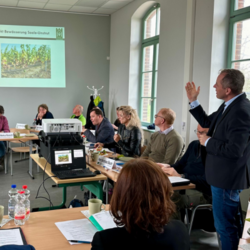 Geschäftsführer der Winzervereinigung  Hans Albrecht Zieger erklärt das Projekt Bewässerung in der Saale-Unstrut Region den am Dialog teilnehmenden Landwirtinnen und Landwirten, sowie den Vertretern aus der Verwaltung