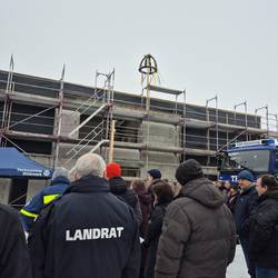 Richtfest THW Neubau Naumburg  – Landrat und Gäste vor dem Rohbau mit Richtkranz