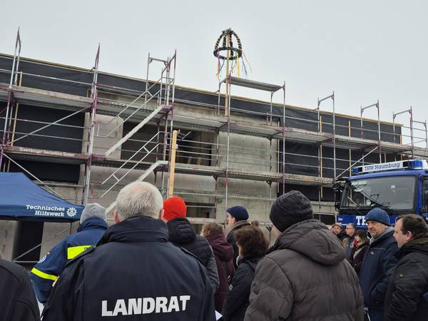 Richtfest THW Neubau Naumburg  – Landrat und Gäste vor dem Rohbau mit Richtkranz