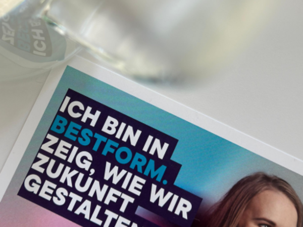 Ausschnitt eines Plakats zum BESTFORM AWARD mit dem Slogan „Ich bin in Bestform. Zeig, wie wir Zukunft gestalten!“ – daneben ein Glas und ein Teil eines Gesichts.